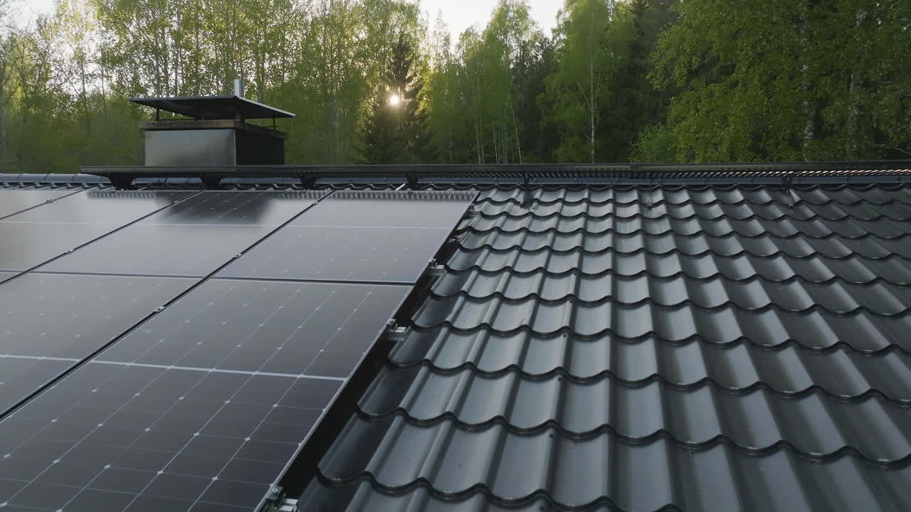 Aerial view close to solar panels on a house roof, on a sunny, summer evening