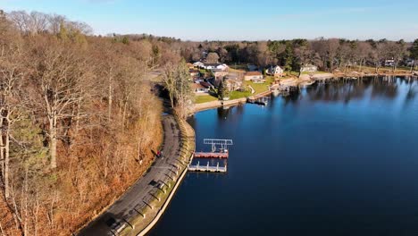 high aerial rotation around a lush and warm scene at a park on a lake