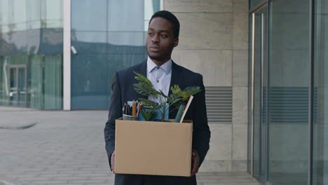 man carrying cardboard box of belongings after being fired