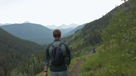 excursionistas caminando cuesta abajo por un sendero a gran altura siguió rockies kananaskis alberta canada