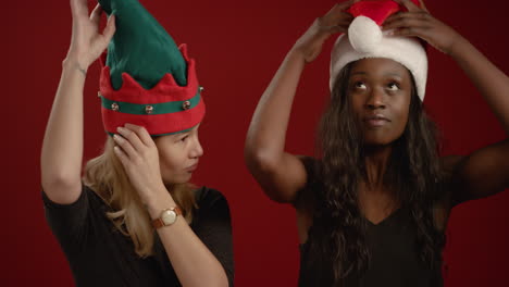 Two-Women-Put-On-Festive-Hats