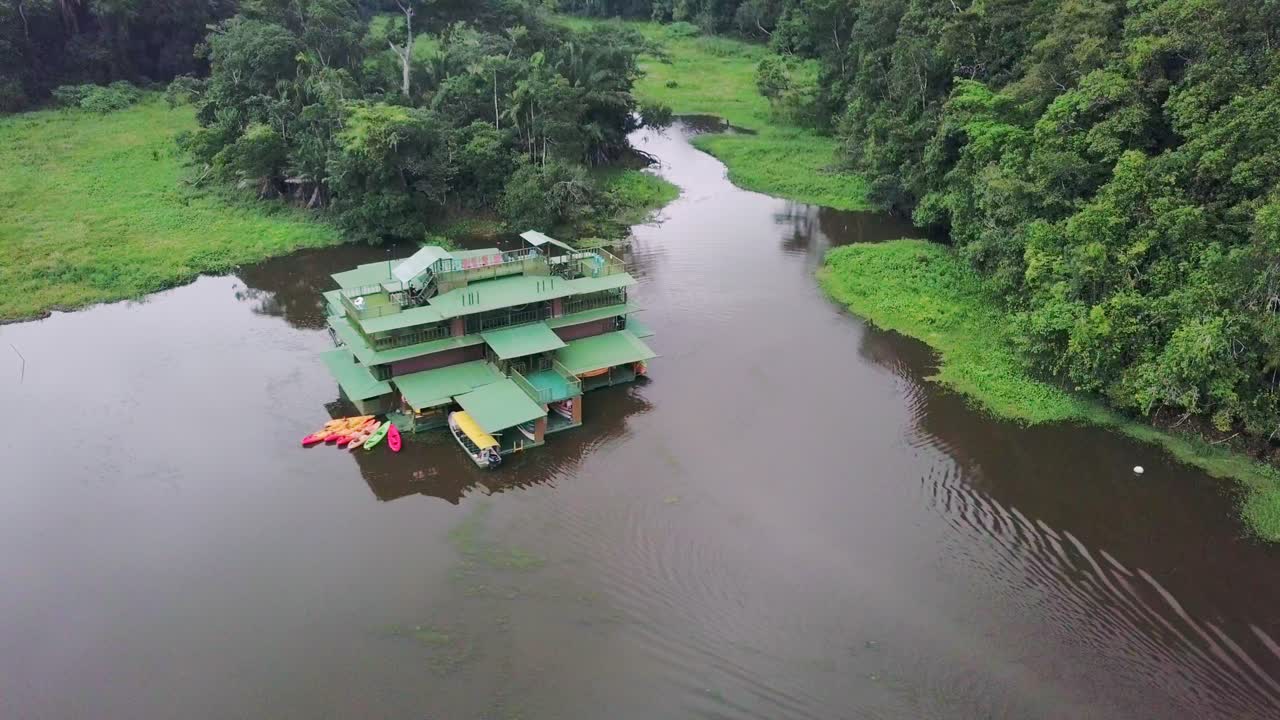 vista aérea de un hotel flotante en un lago aislado en medio del paisaje de la selva tropical en el campo de panamá, tomada por un dron ascendente