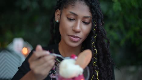 mujer afro latina comiendo helado en un restaurante