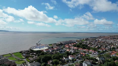 West-Kirby-Marine-Lake-approach,-Wirral,-UK-on-a-bright-and-breezy-summer’s-afternoon---aerial-drone