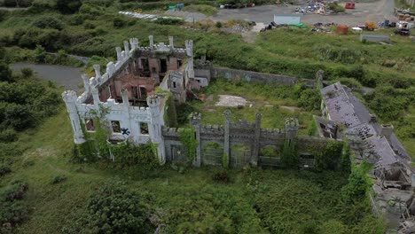 aerial view circling above soldiers point house abandoned holyhead coastal estate and dense woodland