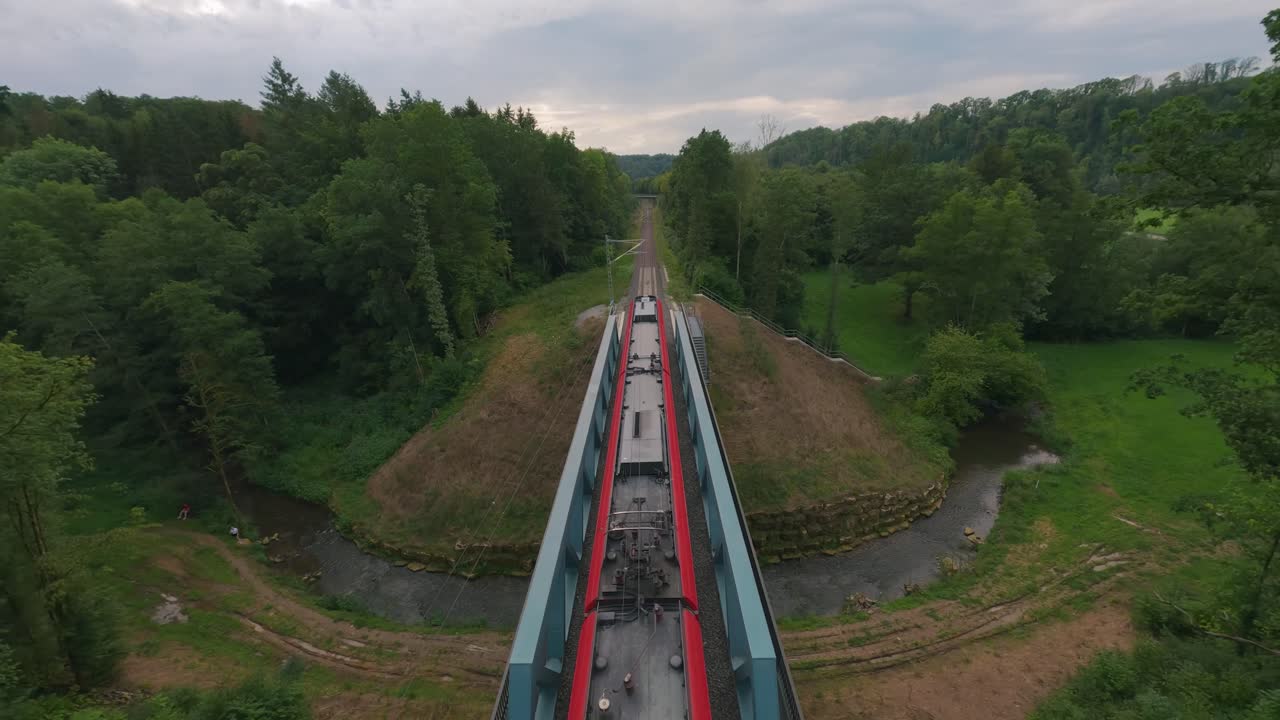 A thrilling FPV drone flight following a train as it moves through scenic German landscapes and vast countryside