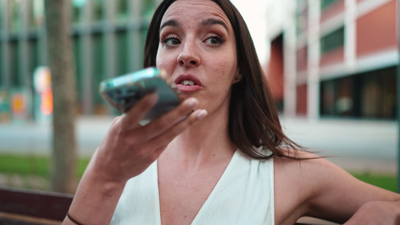Donna che utilizza l'assistente vocale sul telefono all'aperto