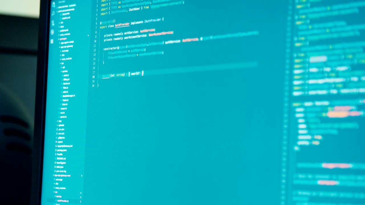 programador de computadora sentado frente a una pantalla codificando software