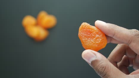 hand holding a dried apricot