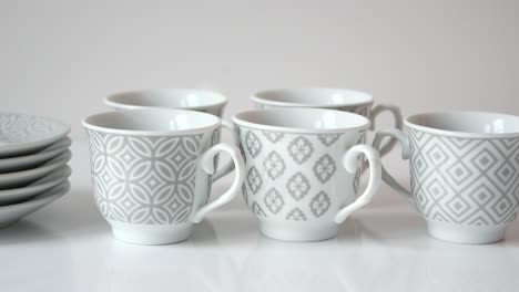 set of grey and white patterned coffee cups and saucers