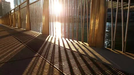 sunrise over city river with metal fence