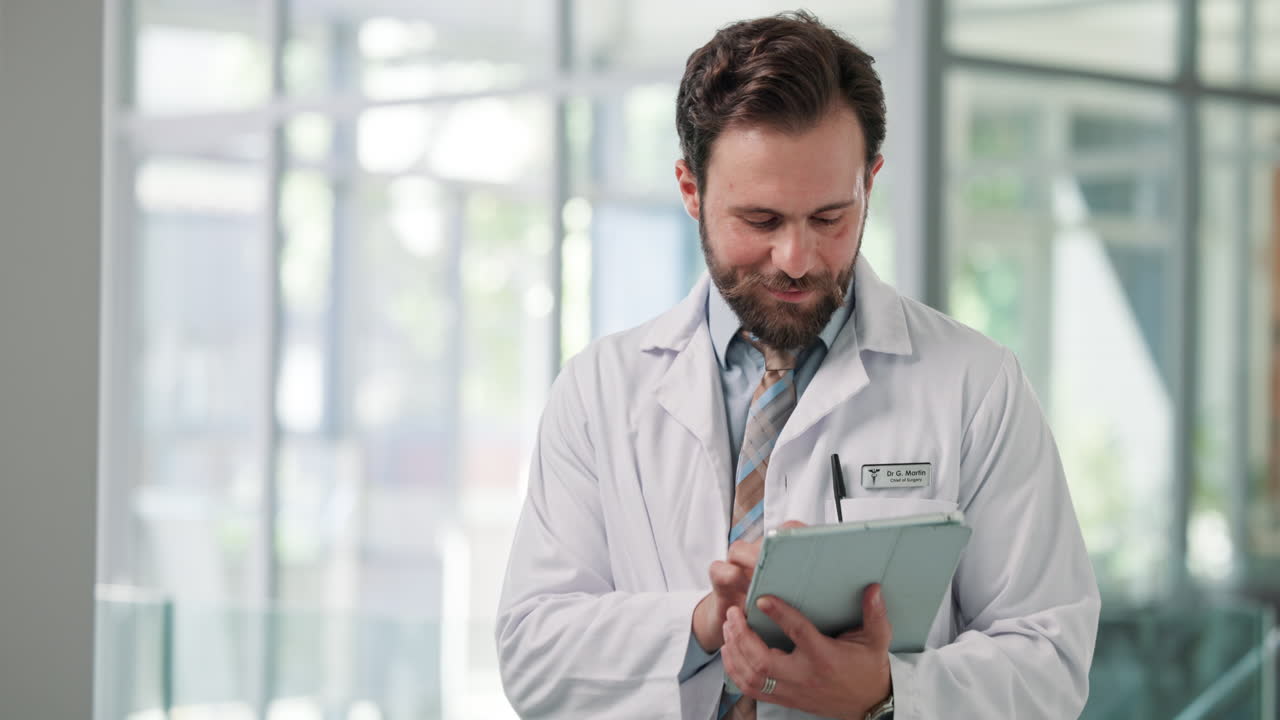 Medico sorridente che usa un tablet digitale in un ospedale moderno