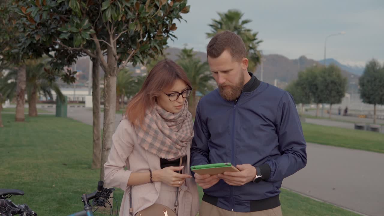 pareja usando una tableta en un parque