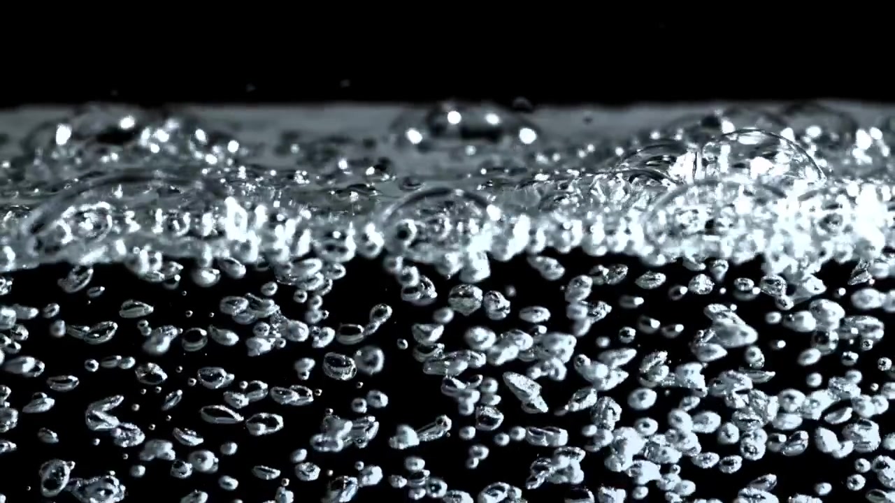 Bolle effervescenti che salgono in acqua pulita su sfondo scuro