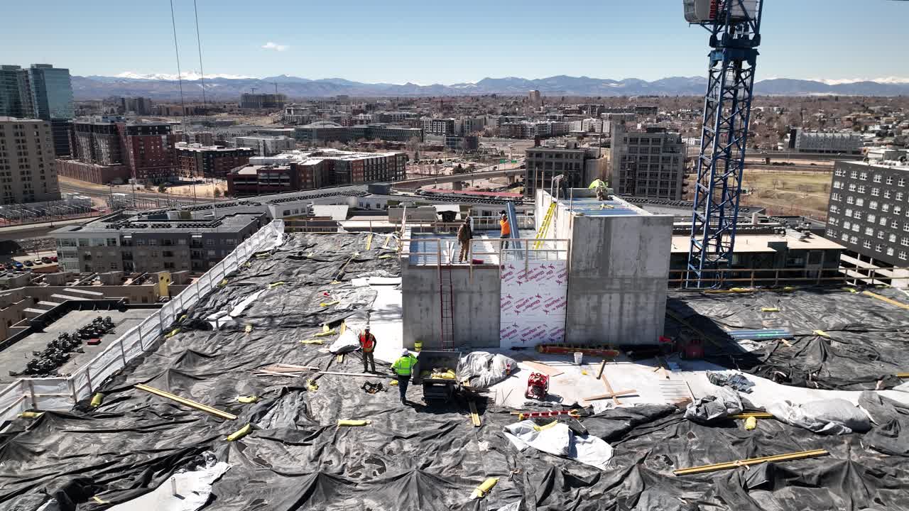 High angle rooftop view of workers at construction site, urban sprawl concept