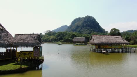 4k-daytime-aerial-view-with-the-beautiful-and-rustic-houses-built-on-the-middle-of-the-calm-waters-of-the-Laguna-de-los-MIlagros-in-Tingo-Maria,-peruvian-amazon