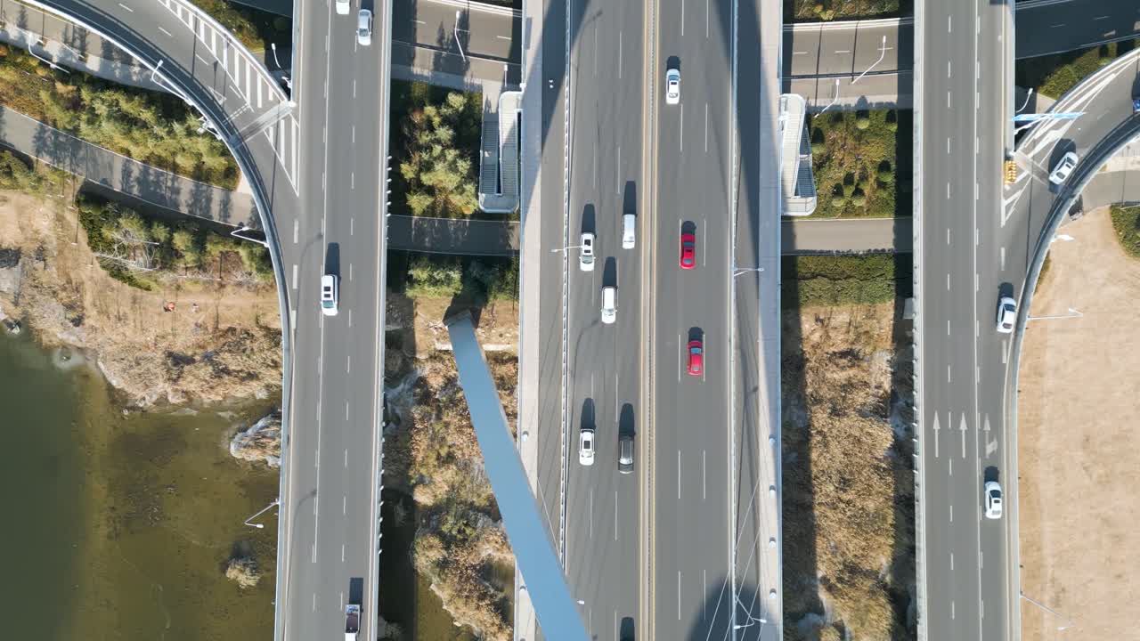 An aerial bird's-eye perspective captures the Shandong Province Linyi Bridge over the Benghe River in China, with flowing car traffic beneath the daytime sunshine