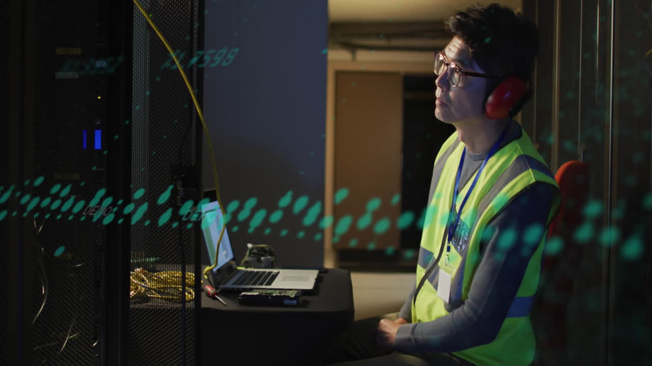 Animation of data processing against asian male engineer using laptop at computer server room