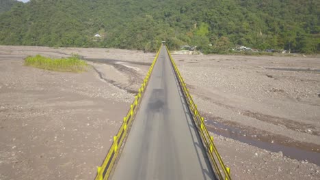 Aerial-drone-video,-old-bridge-along-the-road-that-leads-to-Villavicencio---Colombia,-passing-the-river-Guatiquia