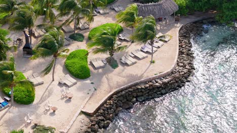 Lounge-chairs-on-sandy-bank-overlook-clear-turquoise-Caribbean-waters-by-Jan-Thiel-and-Zanzibar-beach,-Curacao