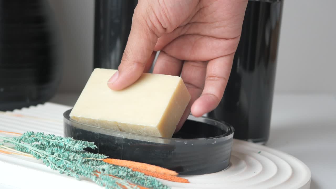 비누 접시 에 비누 를 들고 있는 손