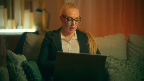 mujer sobrecargada de trabajo navega por internet en la computadora portátil tarde en la noche