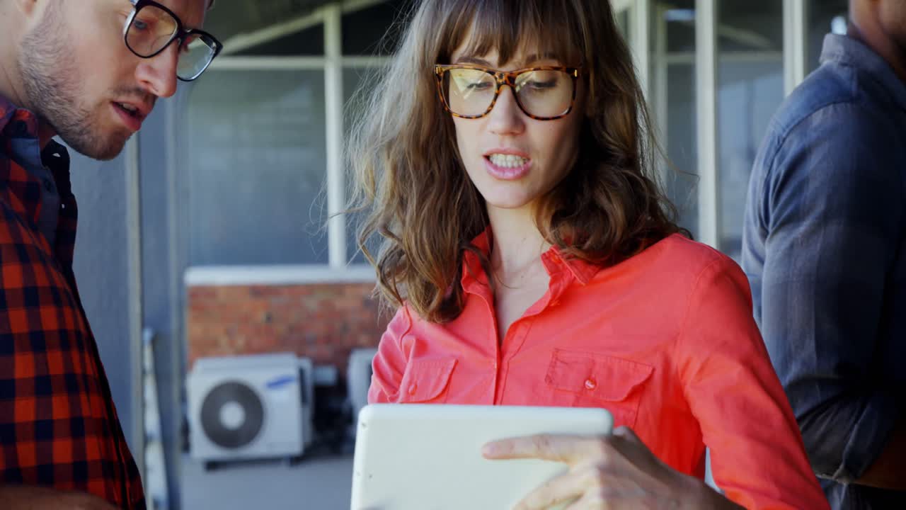 ejecutivos discutiendo sobre una tableta digital