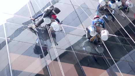 un equipo de lavadores de ventanas limpiando un edificio alto