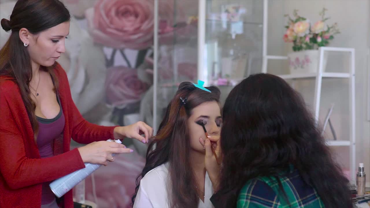 mujer haciendo el cabello y el maquillaje para una boda