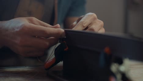 Medium-shot-of-a-clamped-leather-belt-being-hand-stitched