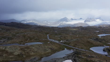norwegian mountain road with glacial peaks and lakes