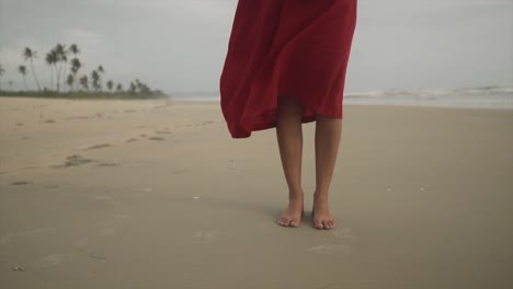 Frauenfüße-In-Einem-Roten-Kleid-Stehen-Am-Meeresstrand-Und-Der-Wind-Weht-–-Wunderschöne-Szene-Einer-Sonnengebräunten-Hübschen-Frau-In-Einem-Roten-Kleid-Mit-Bloßen-Füßen-Am-Meeresstrand