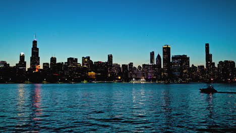 Silhouette-Boat-driving-in-front-of-the-Chicago-skyline,-clear,-summer-dusk