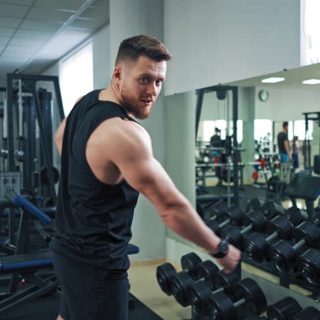 bodybuilder showing his muscular body. bearded athletic man prouds by himself and posing to camera on the fitness center background.