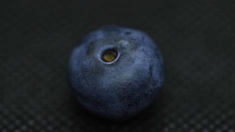 close up macro shot of blueberries laying on dark splashed and spayed water background captured water drops in slow motion