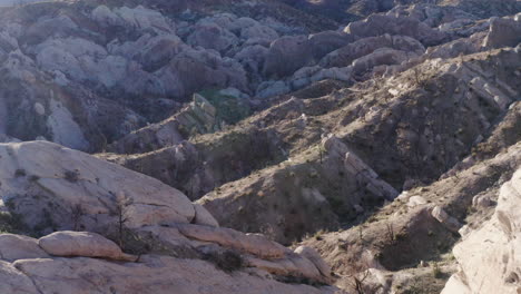 los contornos del suelo en el arco del punchbowl del diablo, disparo de drone hacia atrás
