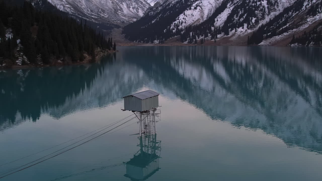vista aérea alrededor de una torre de vigilancia en medio del gran lago de almaty en el nevado kazajstán