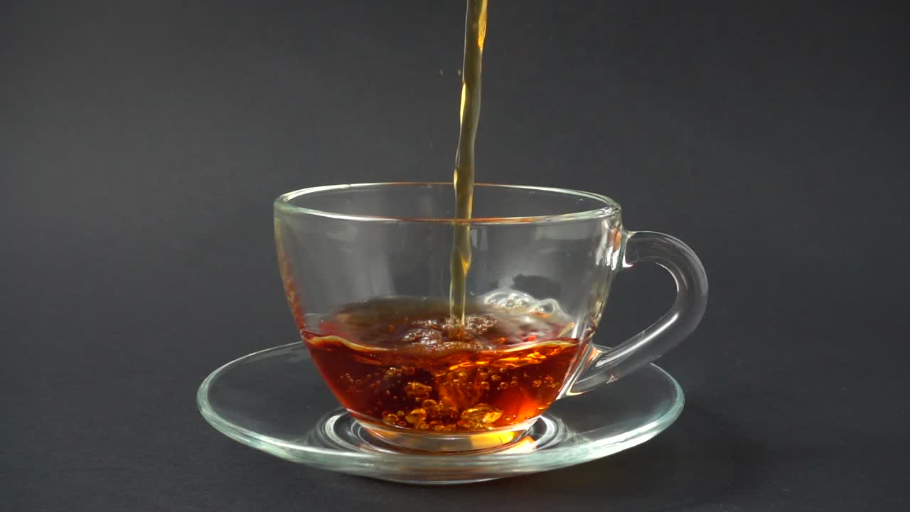 Il tè viene versato nella tazza. Movimento rallentato