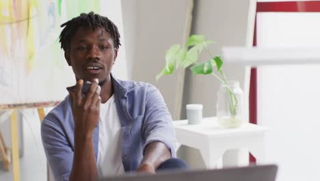 African-american-male-artist-talking-on-smartphone-at-art-studio