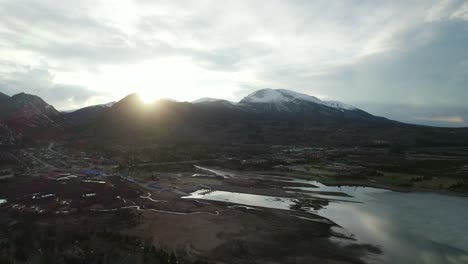 aerial view of a mountain town with a frozen lake at sunset