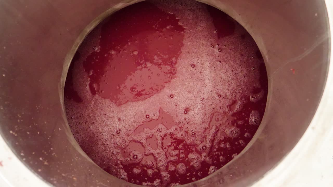 Looking down into a vat of red wine at a wine factory in preparation for bottling