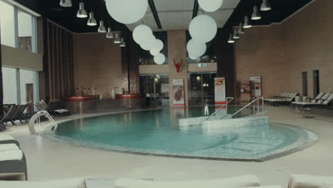 interior of luxury spa center. indoor swim spa with jacuzzi, pool, deck chairs.