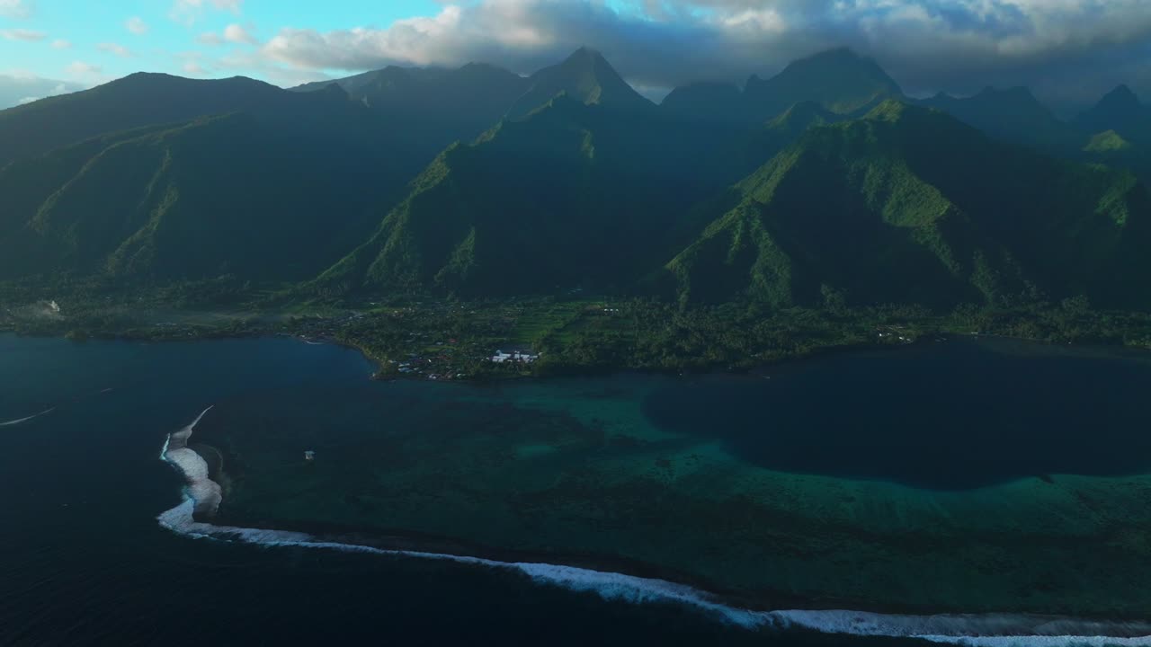 Golden hour sunset towering mountain peaks surf reef break channel Teahupoo Wave Tahiti French Polynesia aerial drone incredible island landscape clouds Olympics Moorea Bora Bora Papeete circle right