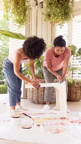 vertical video: assembling furniture together, women enjoying diy project at home