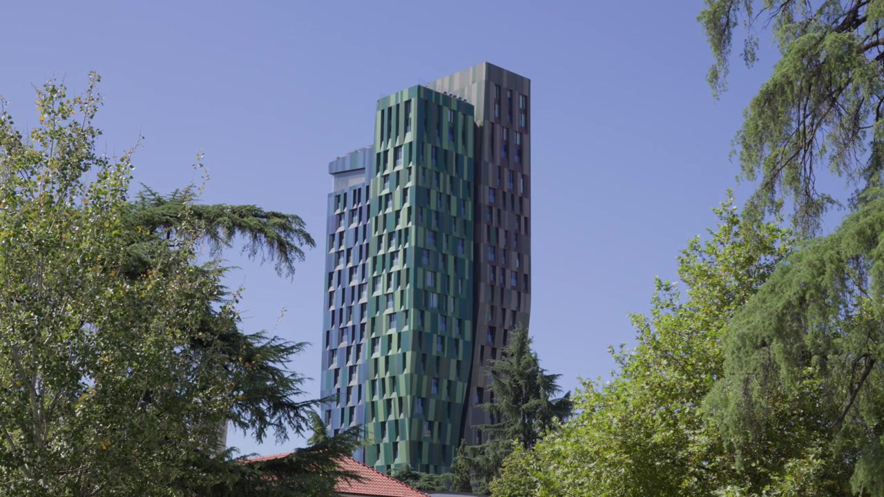 Un video que muestra las coloridas fachadas geométricas del moderno rascacielos Forever Green Tower elevándose sobre exuberantes árboles verdes en Tirana.