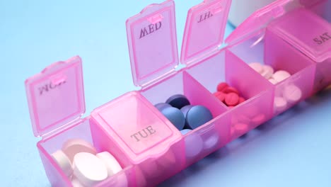 close up of medical pills in a pill box on table