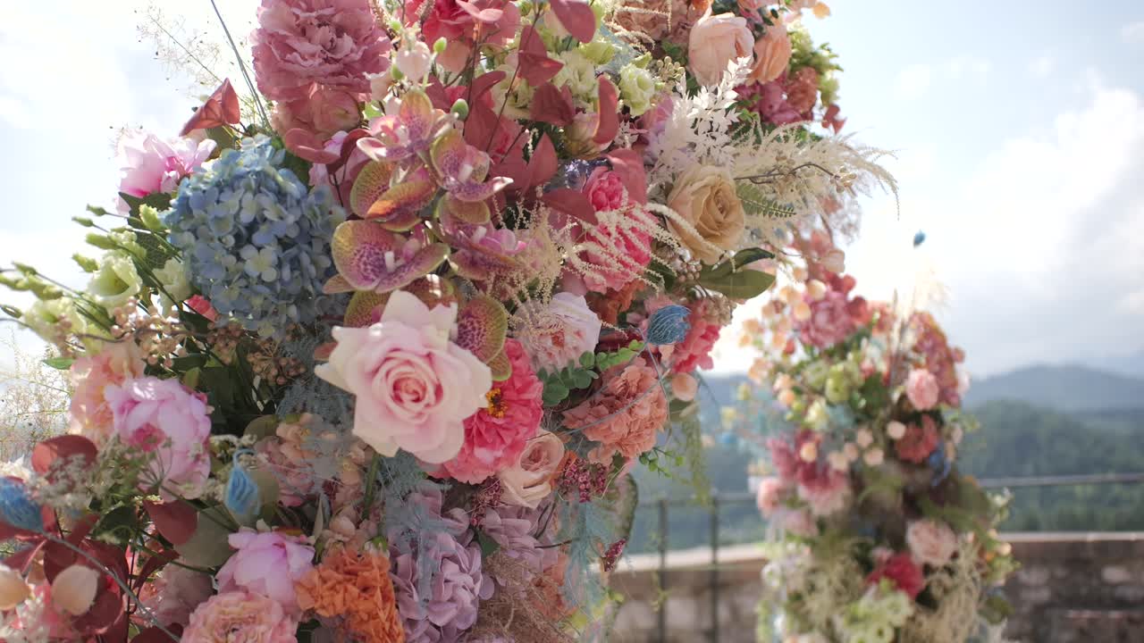 Arco nuziale con fiori colorati, dolly moving shot, atmosfera cinematografica