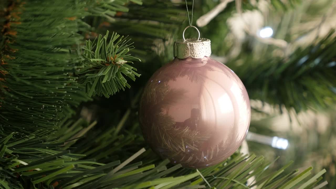 Hermoso adorno de cristal redondo de Año Nuevo. Metraje UltraHD 4K 2160p 30fps - Bola de árbol de Navidad brillante de color rosa claro. Video UHD 3840X2160.