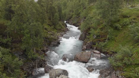 Mountain-river-stream-cascading-down-mountainside,-glacier-meltwater-in-spring