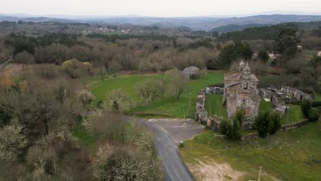 Aerial-pullback-over-Church-of-santa-maria-de-salamonde-in-San-Amaro-Spain-on-grassy-hillside